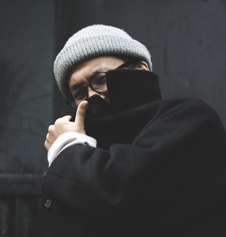 Man hiding his face with his coat collar.