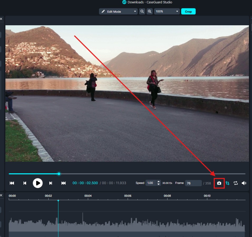 snapshot | CaseGuard Video editing interface showing a lakeside scene with mountains and two people; a red diagonal crop guide highlights the crop tool at the bottom right.