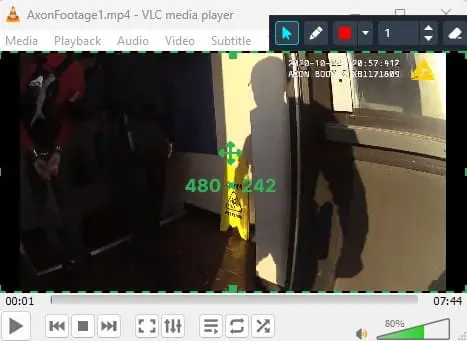 Video frame showing an open doorway with a yellow wet-floor sign, a shadow of a person nearby, and green measurement overlays on screen.